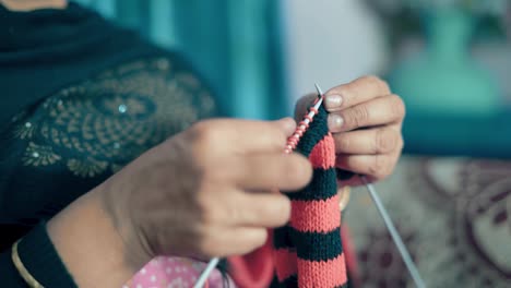 mujer india tradicional teje con agujas artesanales y lana roja y negra