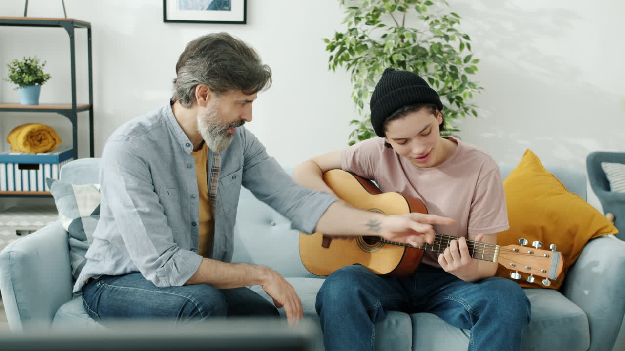 Father teaching his son how to play guitar