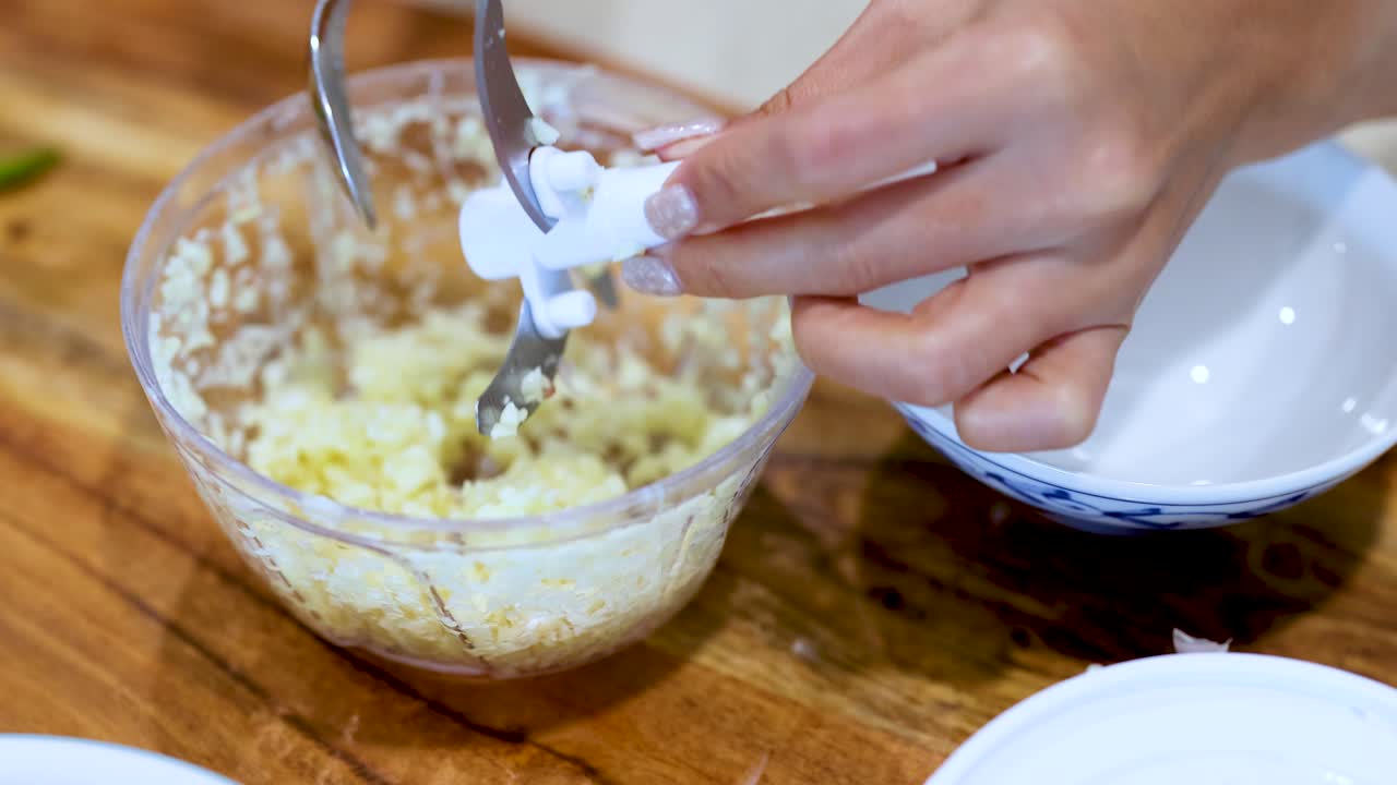 Woman mincing garlic with a food processor