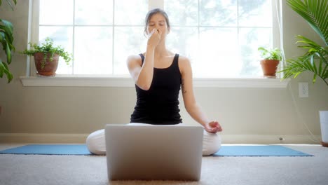 young female yogi teaches an online remote yoga class while in isolation