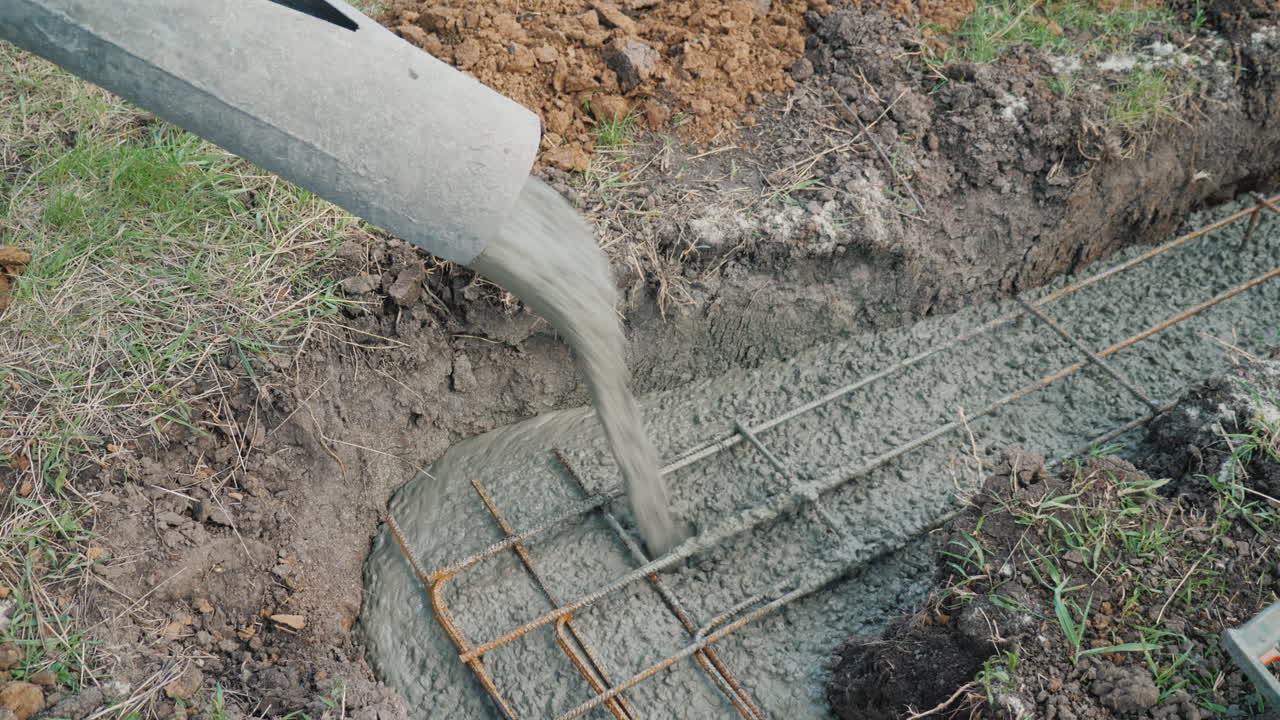 el hormigón fluye a través de la tubería hacia los cimientos del concepto de construcción de cabañas en el sótano