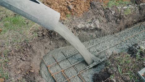 el hormigón fluye a través de la tubería hacia los cimientos del concepto de construcción de cabañas en el sótano