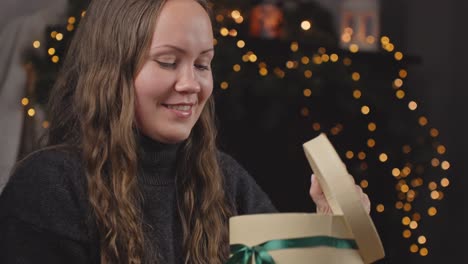 excited woman opening christmas gift, with disappointment returns gift