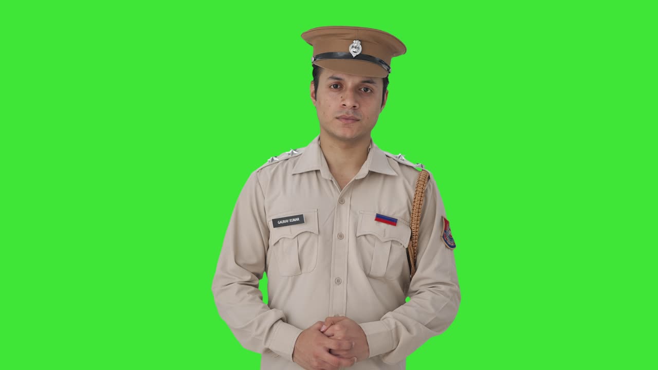 Agente di polizia indiano serio che guarda la telecamera Schermo verde