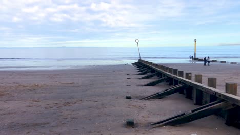 Ein-Alter-Steg-An-Einem-Strand,-Der-Zum-Meer-Führt