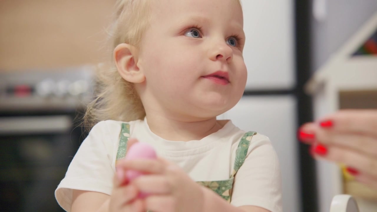 Toddler Girl Playing with Pink Toy in Kitchen