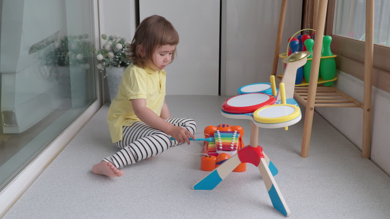 Evinde oyuncak müzik aletleriyle oynayan Koreli-Ukraynalı küçük çocuk.