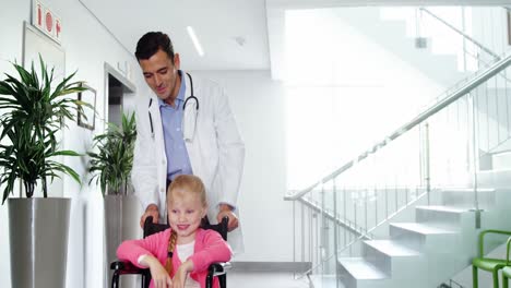 Doctor-pushing-girl-in-wheelchair-