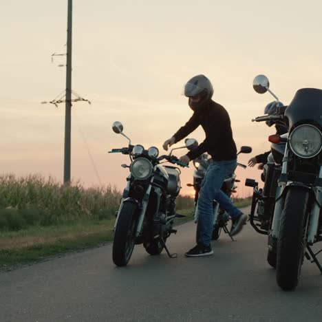 un grupo de motociclistas se suben a sus motocicletas y conducen a 2