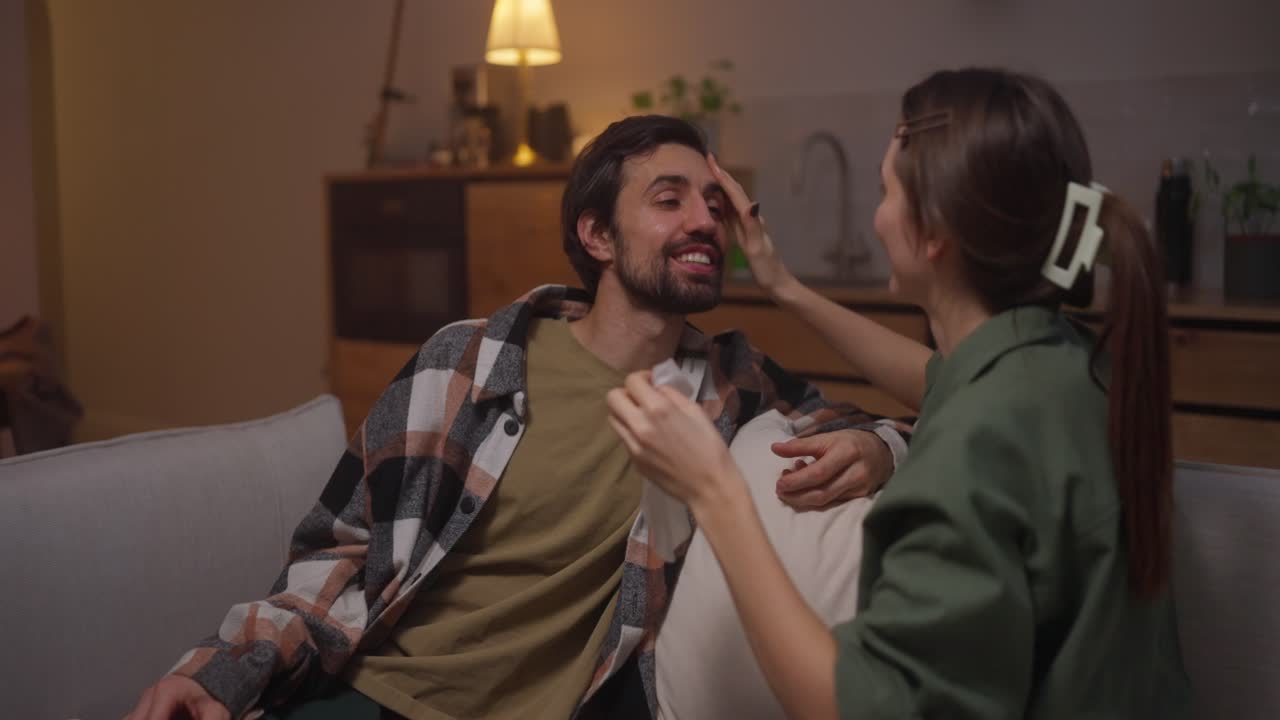 저녁 에 집 에서 소파 에 안고 있는 부부