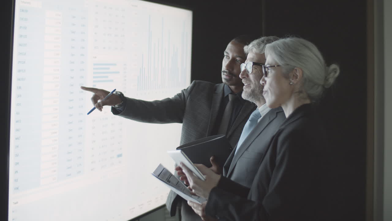 동료들에게 통계를 설명하는 흑인 남성 금융 컨설턴트