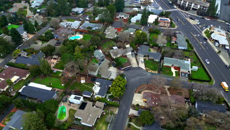 Aerial-drone-establishing-shot-above-walnut-creek-california-usa-neighborhood-street-roads-and-traditional-american-houses,-trees-and-traffic-driving-by-asphalted-road-in-slow-motion