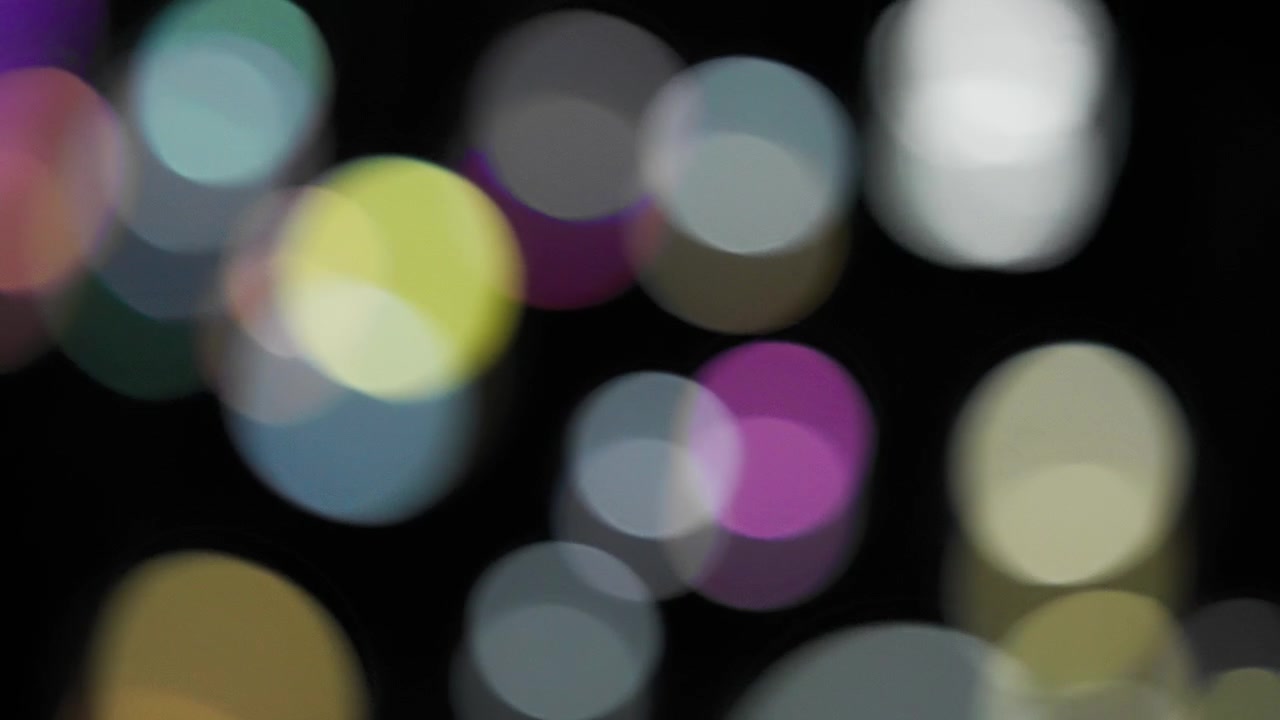 Abstract bokeh background of falling colorful soap bubbles. Slow motion