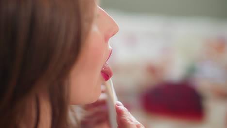 Woman with pink lipstick kisses Valentine&#039;s Day card sealed in slow motion
