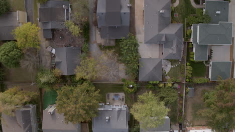 overhead view of suburban houses and trees with descent downward