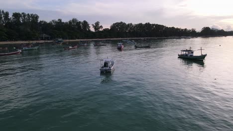 Drone-aerial-slow-move-over-tropical-blue-water-during-sunrise-with-Thai-speedboats-around