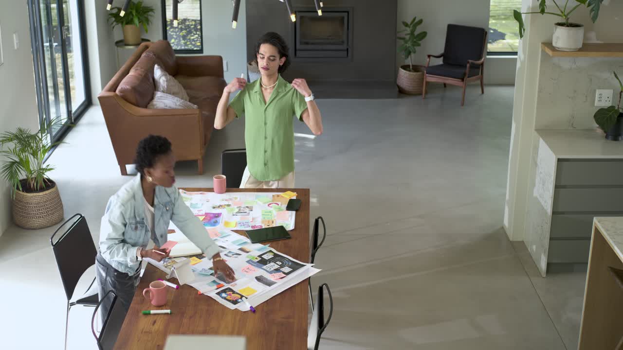 Diverse coworkers starting brainstorming outlining ideas arranging prints at studio for layout