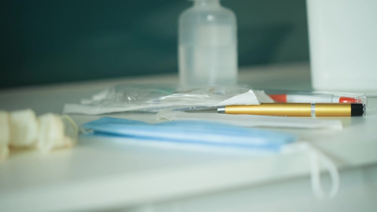Medical supplies prepared. Hospital equipment including mask sanitizer and pen neatly set up. Restockready medical tools such as mask sanitizer and pen placed on white surface with clinical lighting