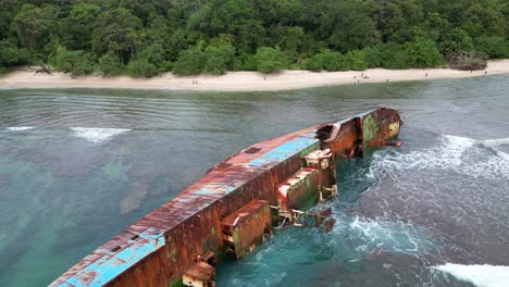 Naufragio-Oxidado-Tendido-De-Costado-Mientras-Las-Olas-Chocan-En-Pangandaran,-Indonesia