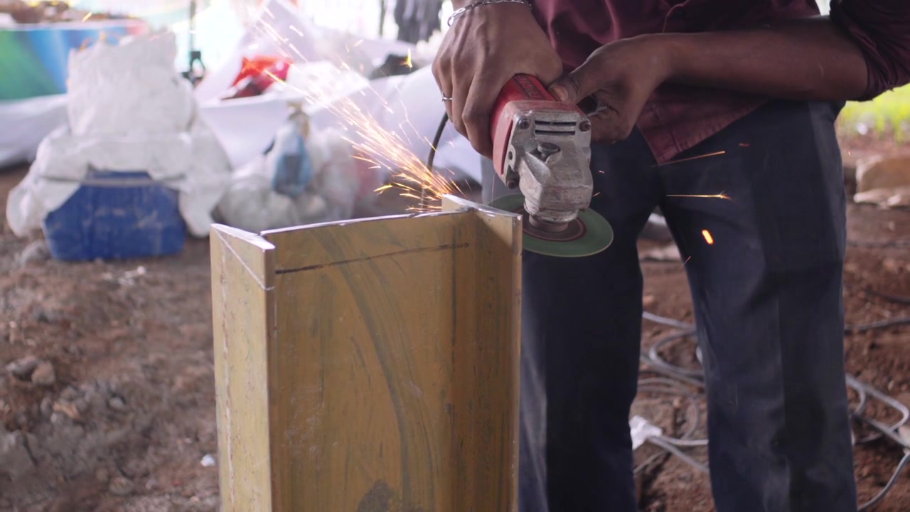He is cutting a large iron rod with a grinding machine closeup view