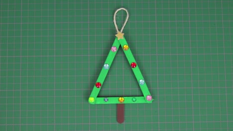 christmas tree made with popsicle sticks on a cutting mat