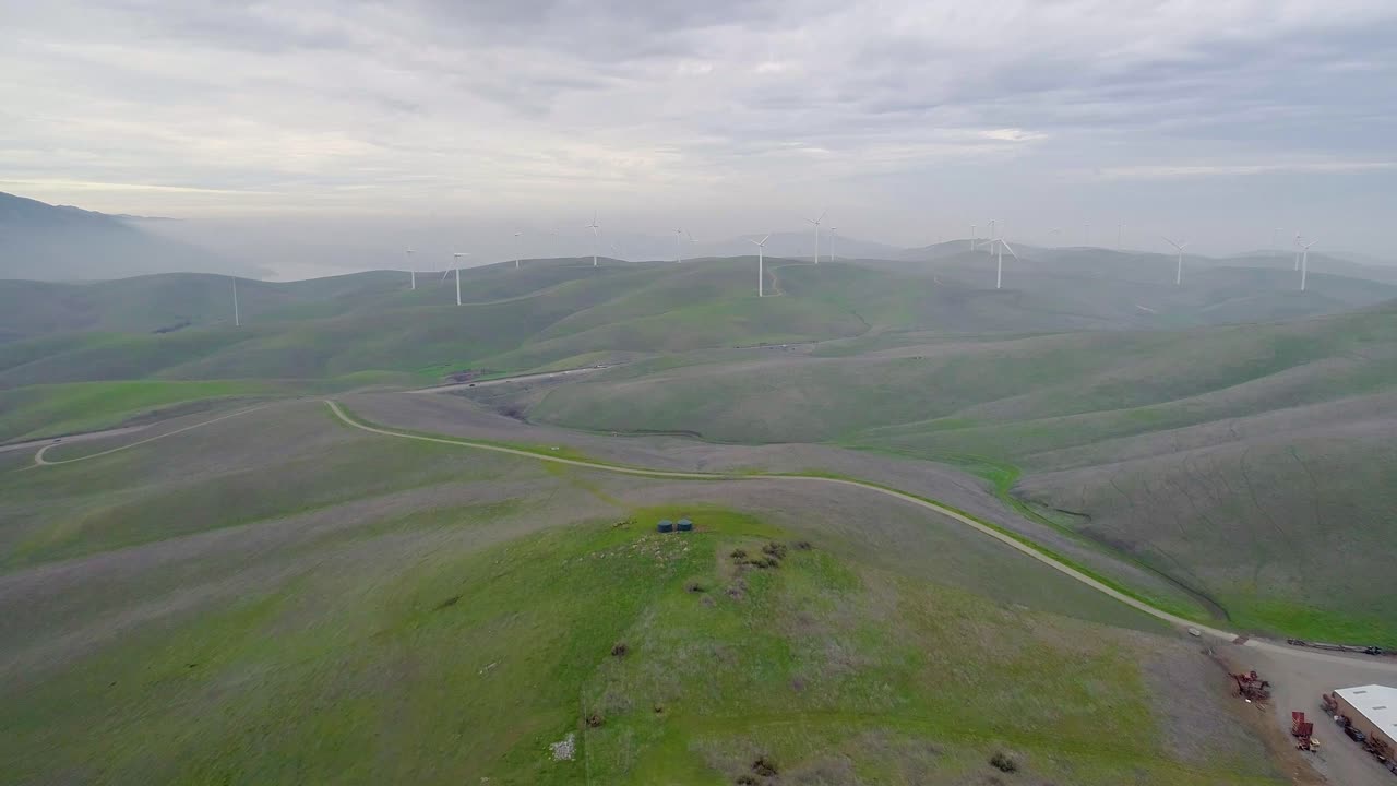 Reverse Dolly of Distant Wind Turbines Engulfed in Smokey Mountain Mist