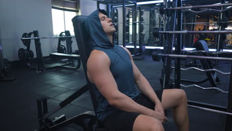 tired caucasian athlete sportsman takes break at sport gym exhausted sweaty bodybuilder hard breathing rest after weightlifting exercise workout seated on bench relax