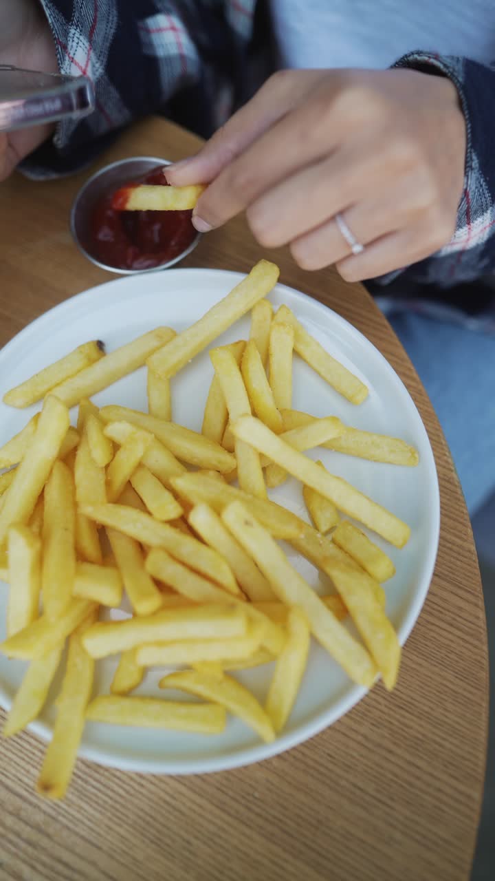 mujer comiendo papas fritas en una cafetería