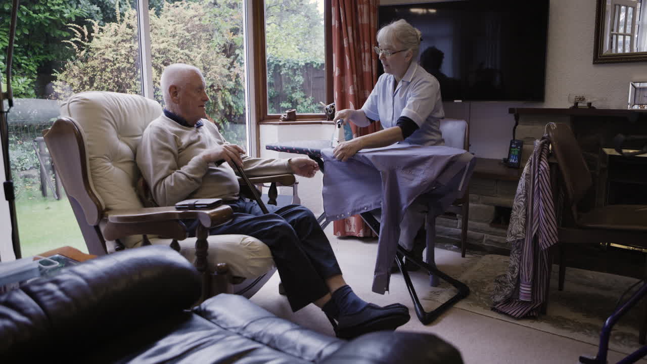 Elderly man receiving home care from a caregiver