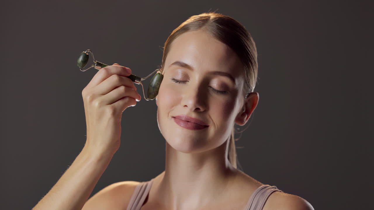 Woman using a face roller for skincare
