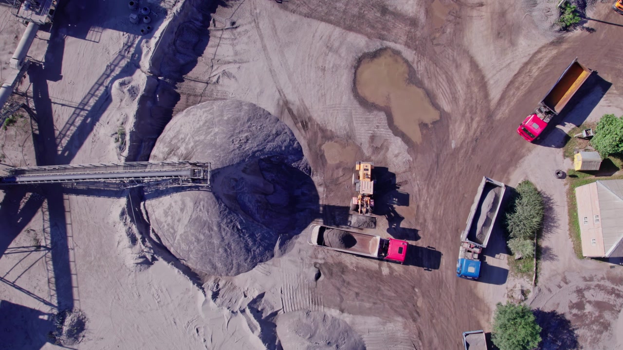 Overhead view of a busy quarry with trucks and machinery