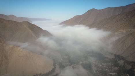 drone shot of a valley full of mist and a view of mountains in peru