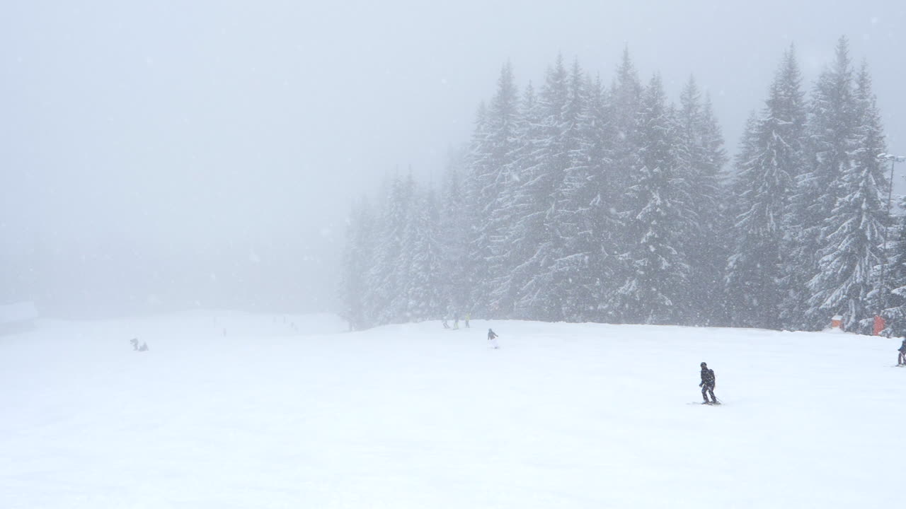 눈 내리는 동안 스키를 타는 사람들. 정적, 슬로모