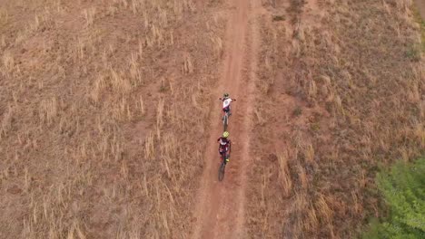 drone siguiendo a dos ciclistas de montaña en un día nublado