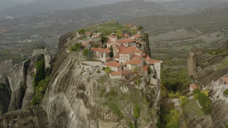 Aerial-view-circling-a-hilltop-cloisters-of-Meteora,-Greece---orbit,-drone-shot