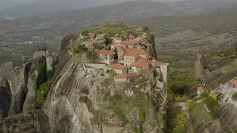 vista aérea que rodea los claustros de una colina de meteora, grecia - órbita, disparo de drones