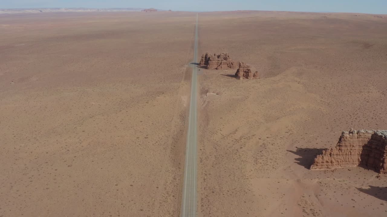 유타 고속도로 옆에 있는 작은 암석층을 향해 사막 도로를 가로지르는 공중 전망