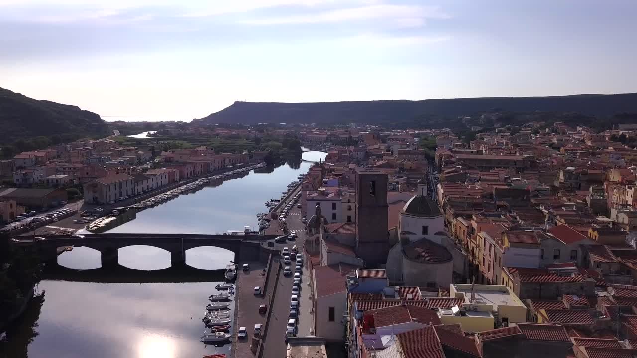 Bosa, Sardinia - Drone aerial shot at sunset over the colourful town of Bosa and the stone bridge on the river temo in Sardinia