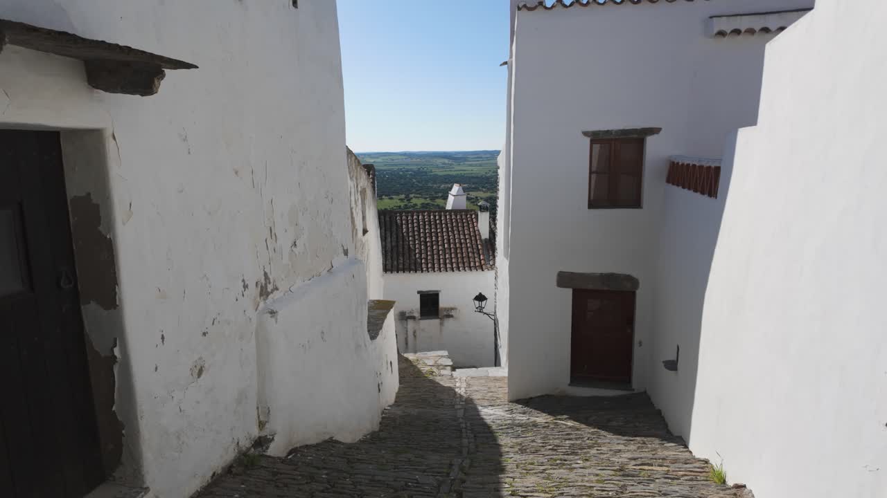 Narrow cobbled path with distant valley view in Monsaraz Portugal