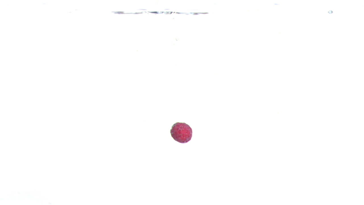 frambuesa cayendo en el agua en cámara súper lenta