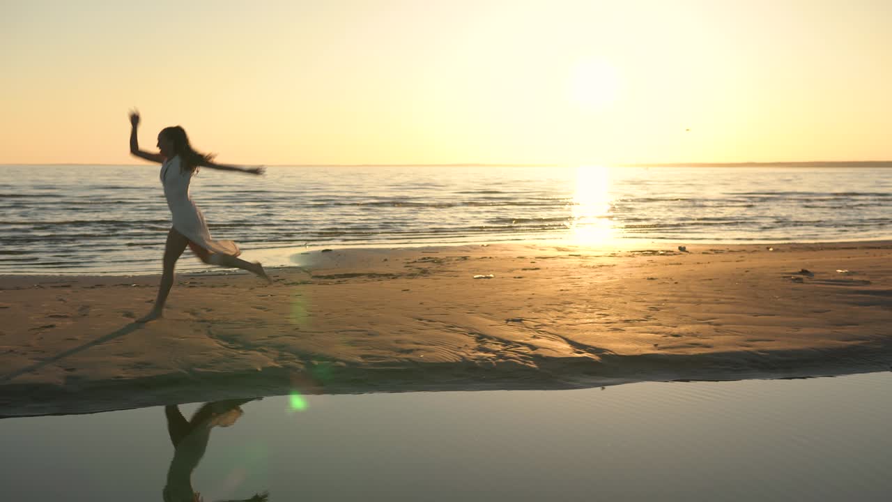 해변에서  드레스를 입은 젊은 여성이 춤을 춘다