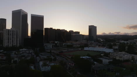 Ascending-aerial-view-of-the-skyline-of-Beverly-Hills,-sunset-in-Los-Angeles,-USA