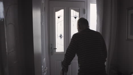 man standing in a hallway near a door