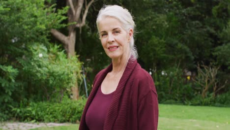 Animation-of-caucasian-senior-woman-smiling-at-camera-in-garden