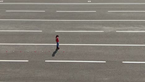 athlete trains in the open area, goes round the cones, slalom, criss cross. athlete takes acceleration and goes on roller skates. view from the copter. 4k, 10bit, prores