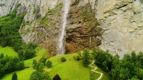 lauterbrunnen staubbach falls, surrounded by lush green hills and alpine nature