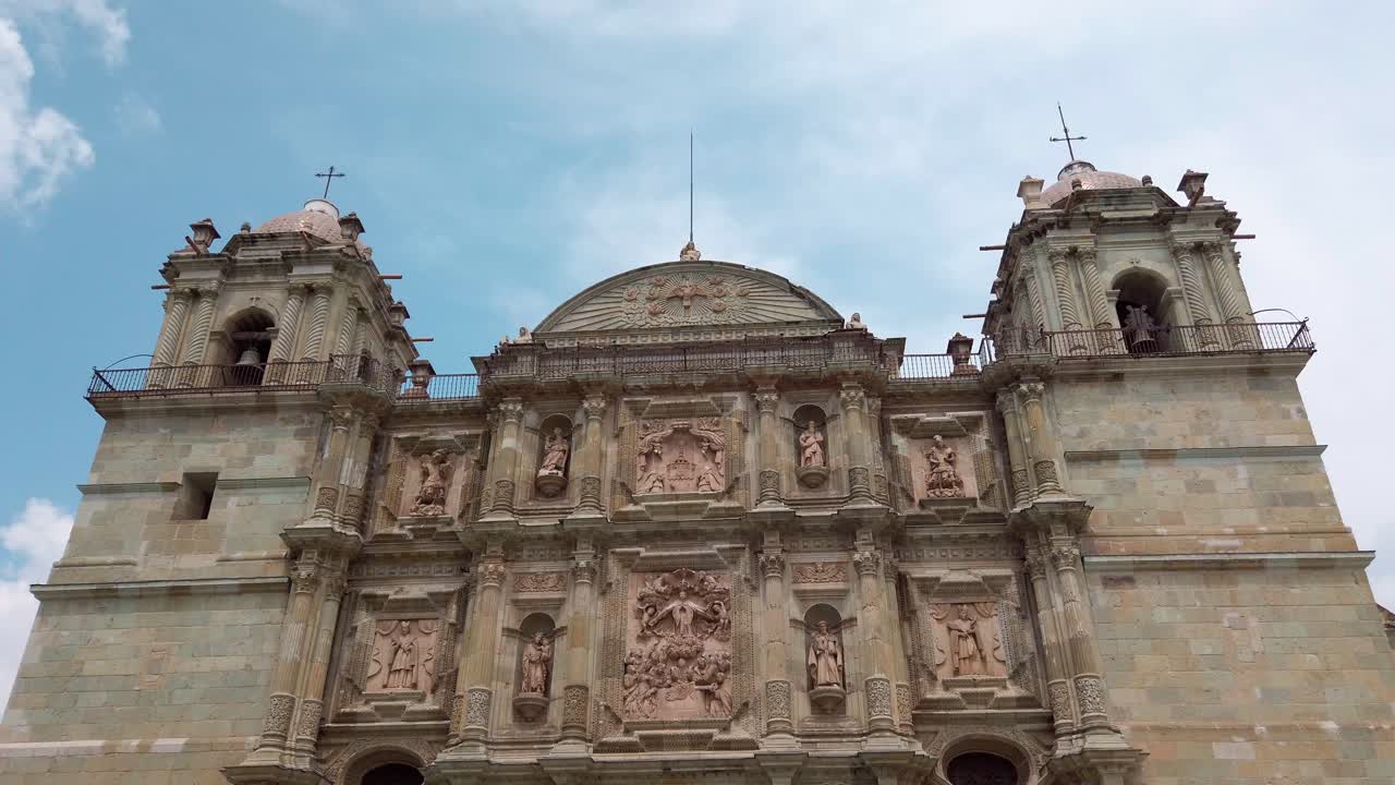 Zoom in on ornate baroque church facade in Oaxaca, highlighting detailed stonework and architecture