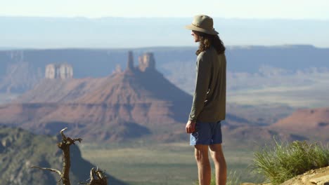 Young-man-with-long-curly-hair-enjoys-Castle-Valley-view,-Moab-canyon