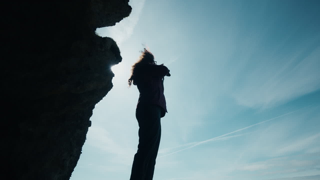 Wide angle shot from inside Yoda Cave, Iceland, woman taking picture, moody silhouette 02