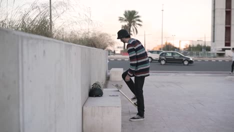 man tying shoes on a skateboard outside